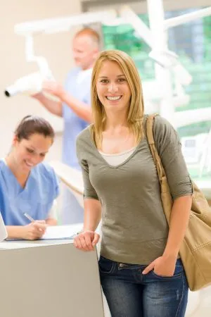 smiling woman at the front desk of a dental office